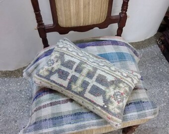 Puede incluir: Una silla de madera con un asiento y respaldo de tela estampada. La silla tiene dos cojines en el asiento, uno con un patrón geométrico y el otro con un patrón a rayas.