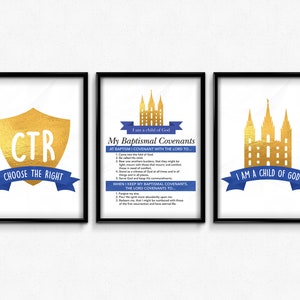 May include: Three framed art prints with black frames. The prints feature gold and blue designs with text. One print has a gold shield with "CTR" and "CHOOSE THE RIGHT". Another has text about baptismal covenants. The third print has a gold building design and the text "I AM A CHILD OF GOD".
