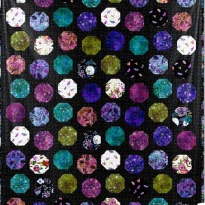 May include: A quilt with a black background and a pattern of octagons in various shades of purple, blue, green, and white. Each octagon features a different floral or butterfly design.