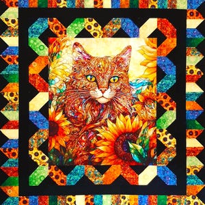 May include: A colorful quilt featuring a detailed image of a cat surrounded by sunflowers. The cat has orange and brown fur with yellow eyes. The quilt has a black border with a geometric pattern in various colors, including orange, green, and blue.