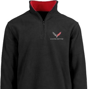 May include: Black fleece pullover with a red inner lining and a Corvette logo on the chest. The logo is silver and red with the word "Corvette" underneath.
