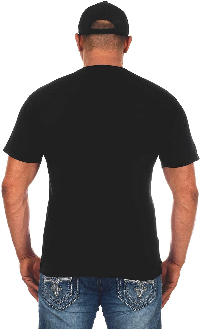 Pode incluir: Uma camiseta preta de manga curta com um bon&eacute; de beisebol preto. A pessoa est&aacute; vestindo jeans azul com costuras prateadas.