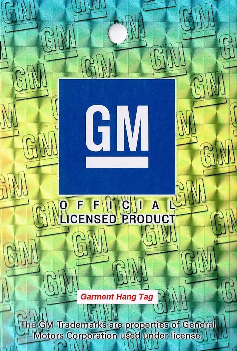 Pode incluir: Uma etiqueta de pendurar azul com um logotipo "GM" branco e o texto "PRODUTO OFICIAL LICENCIADO". O fundo &eacute; um padr&atilde;o hologr&aacute;fico verde e azul com o logotipo "GM" repetido.