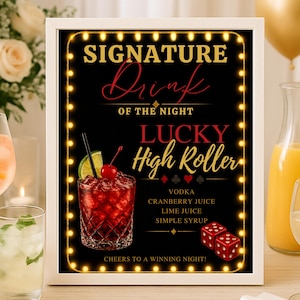 以下が含まれることがあります： 金色の文字とライトストリングが付いた、額入りの黒い看板。「SIGNATURE Drink OF THE NIGHT LUCKY High Roller」と書かれており、飲み物の材料が記載されています。カクテルとサイコロが描かれています。他のカクテルと風船が背景にあります。