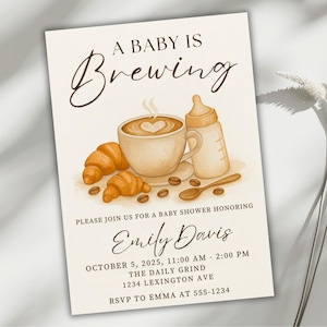 Pode incluir: Convite para chá de bebé com tema de café. O convite apresenta uma ilustração em aquarela de uma xícara de café com um design de coração, croissants, uma mamadeira e grãos de café. O texto diz "A Baby is Brewing" e inclui detalhes do evento.