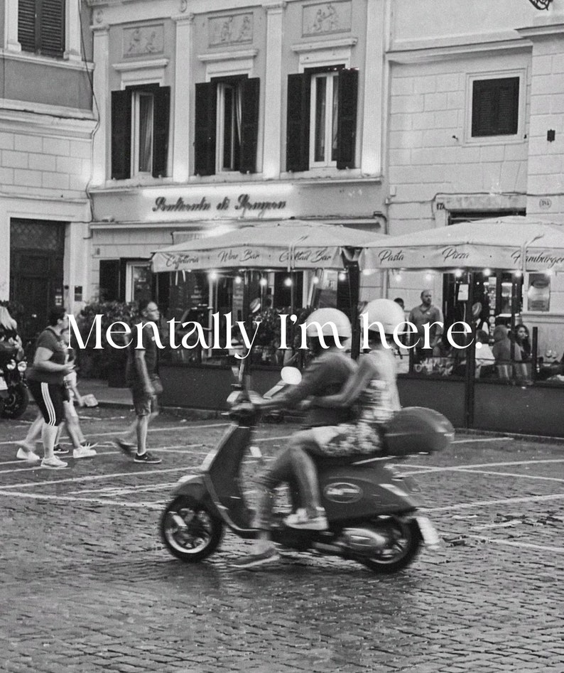 Pu&ograve; includere: Una foto in bianco e nero di una coppia su uno scooter rosso davanti a un bar a Roma, Italia. Il testo "Mentally I'm here." &egrave; sovrapposto all'immagine.