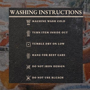 May include: A black rectangular sign with white text detailing washing instructions. The text includes: machine wash cold, turn item inside out, tumble dry on low, hang for best care, do not iron design, and do not use bleach.