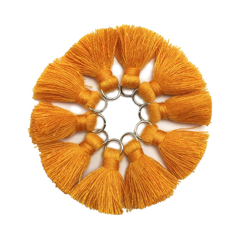 May include: Ten small, bright yellow tassels with silver rings. The tassels are arranged in a circle.