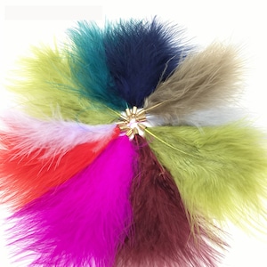 以下が含まれることがあります： ターコイズ、ネイビー、ベージュ、ホワイト、レッド、ピンク、バーガンディー、グリーンなど、さまざまな色の10本のフェザーボアのアソート。各ボアにはゴールドメタルチップが付いています。