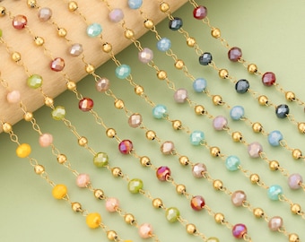 Puede incluir: Primer plano de varios hilos de cadena de cuentas de colores. Cada hilo presenta pequeñas cuentas redondas de color dorado que se alternan con cuentas facetadas e iridiscentes en varios colores, incluyendo amarillo, rosa, verde y azul. Las cadenas están dispuestas en diagonal.