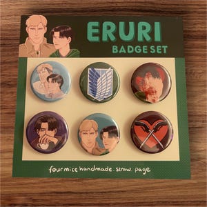 May include: A set of six round pins featuring characters from the anime Attack on Titan. The pins are arranged in a grid on a green background with the text "ERURI BADGE SET" and "fourmice handmade. straw. page".