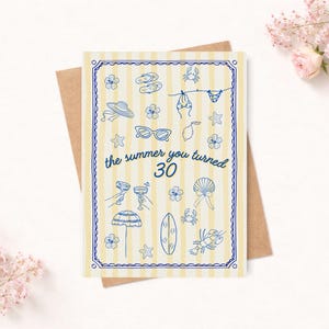 May include: Greeting card with a summer theme, featuring a yellow and white striped background and blue illustrations of beach items. The text "the summer you turned 30" is displayed in the centre. The card is on a brown envelope.