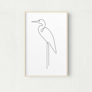 May include: A black and white line drawing of a heron standing on one leg on a branch. The heron is facing to the right and has a long neck and beak.