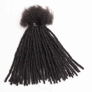 Op de afbeelding: Een bundel zwarte dreadlocks van echt haar, gebonden met een zwart elastiek.