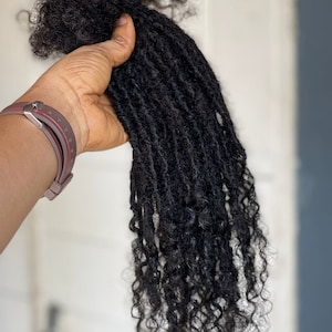 May include: A long, thick bundle of black dreadlocks hair extensions.