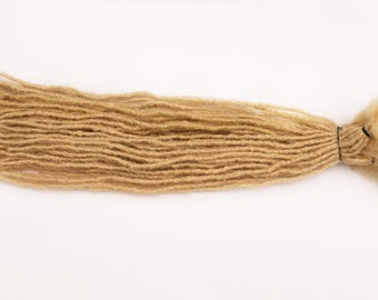 May include: A long strand of light brown synthetic dreadlock hair extensions.