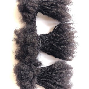 May include: Three bundles of black human hair dreadlocks, tied together with rubber bands.