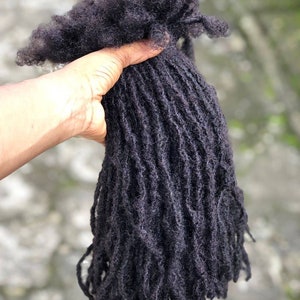 May include: A bundle of black human hair dreadlocks.