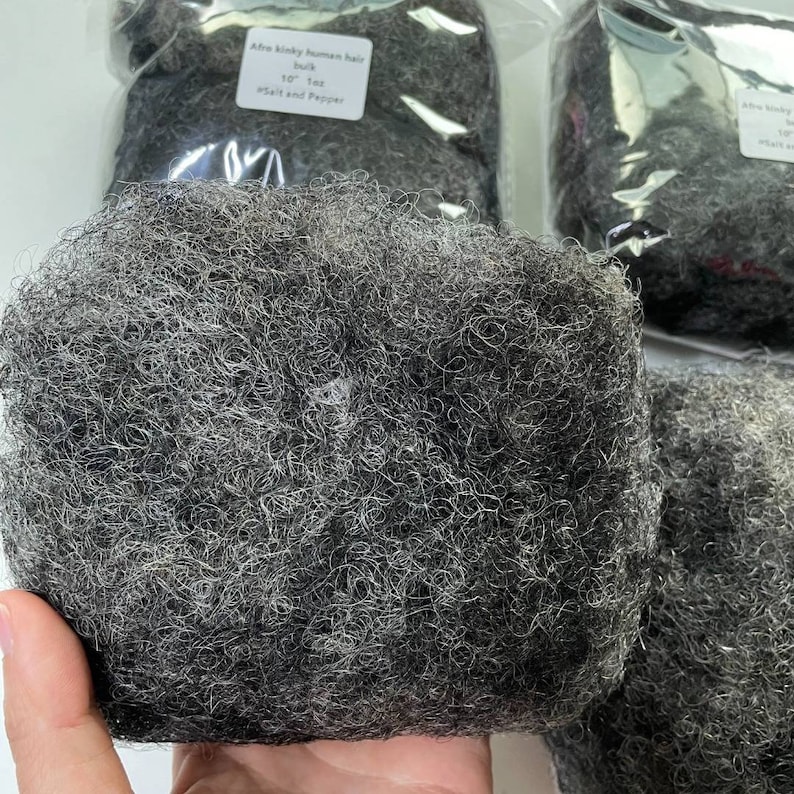 May include: A close-up of a bundle of Afro kinky human hair in salt and pepper color. The hair is 10 inches long and is packaged in a clear plastic bag.