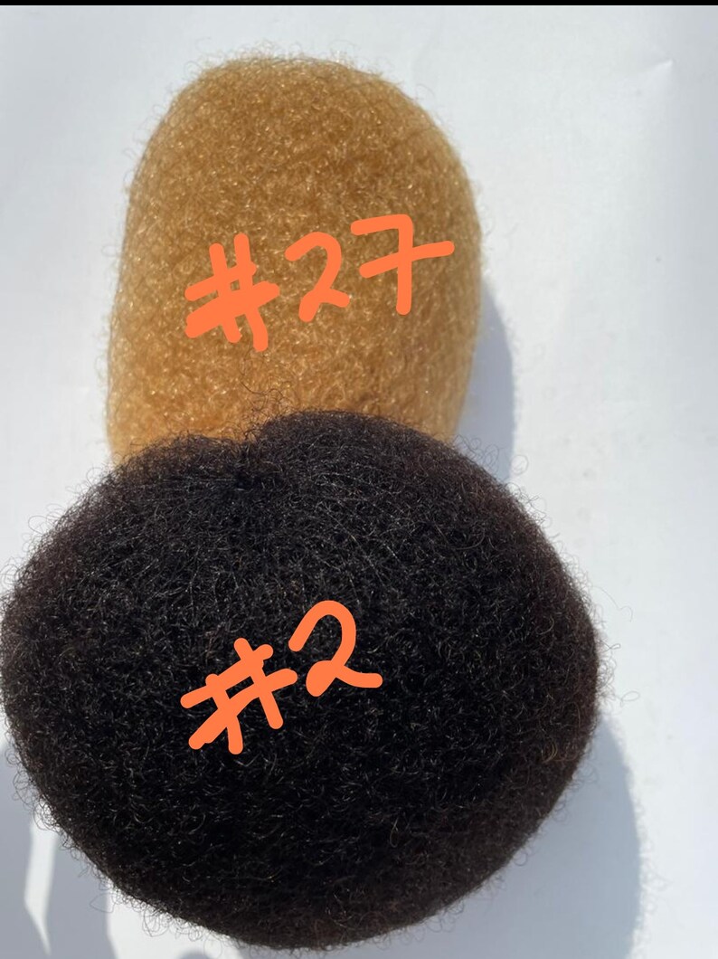 May include: Two afro hair bundles, one is a light brown color labeled #27 and the other is black labeled #2.