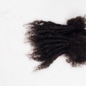 Może przedstawiać: Paczka ciemnobrązowych przedłużaczy włosów ludzkich o kręconej strukturze.