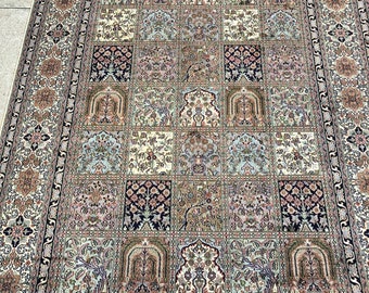 May include: A traditional Persian rug with a cream background and a central design of a repeating pattern of squares with floral motifs. The rug has a dark blue border with intricate floral designs.