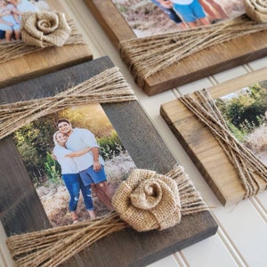 May include: Four rustic wooden picture frames with burlap rope accents and burlap flower embellishments. Each frame holds a photograph of a family.