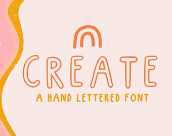 May include: A hand-lettered font design with the word "CREATE" in orange with a small orange rainbow above the word. The text "A HAND LETTERED FONT" is below the word "CREATE" in yellow.