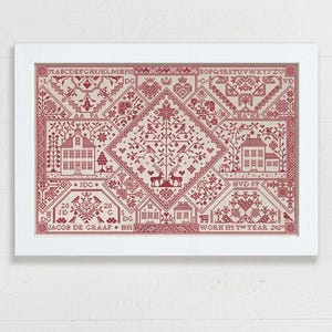 May include: A framed cross-stitch sampler featuring intricate red geometric patterns, houses, trees, and deer on a light beige fabric. The design includes the alphabet, the text JACOB DE GRAAF, and WORK IN THE YEAR 2020, all enclosed in a white frame.