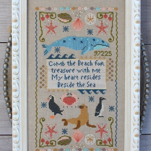 May include: Cross-stitch pattern featuring a whale, sea lion, puffin, and penguin with a quote that reads "Comb the Beach for treasure with me. My heart resides Beside the Sea."