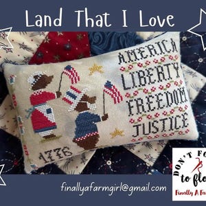 May include: A rectangular cross-stitch pillow featuring two brown bears holding American flags. The text reads America, Liberty, Freedom, Justice, and 1776. The bears wear red, white, and blue clothing. The background is a cream fabric with stars.