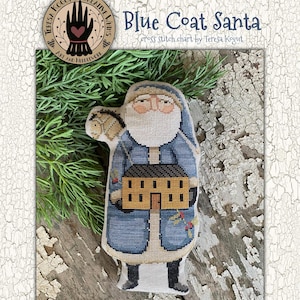 May include: A cross-stitch pattern featuring a Blue Coat Santa holding a house. The Santa figure is dressed in a blue coat with black boots and has a white beard and rosy cheeks. The text "Blue Coat Santa" is displayed above the image.