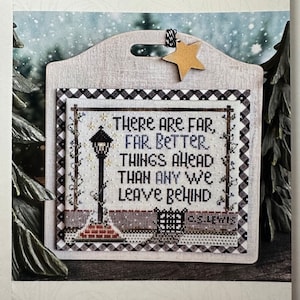 May include: A cross-stitch pattern featuring a winter scene with a street lamp and the text "There are far, far better things ahead than any we leave behind".