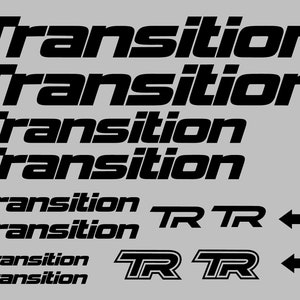 May include: A set of black vinyl decals featuring the word "Transition" in various sizes, ranging from 13 inches by 1.5 inches to 4 inches by 0.5 inches. The set also includes two smaller decals with the letters "TR" in a bold, stylized font.