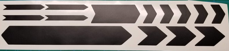 May include: A sheet of black vinyl stickers with arrow shapes. The stickers are designed to be applied to a bicycle frame.