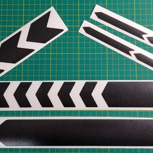 May include: A set of black chevron bike frame decals. The decals are on a white background and are ready to be applied to a bike frame.