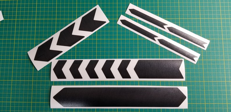 May include: A set of black chevron bike frame decals. The decals are on a white background and are ready to be applied to a bike frame.
