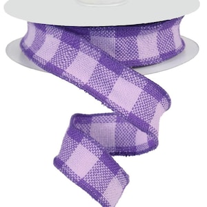 Puede incluir: Cinta a cuadros de color morado y blanco con textura tejida. La cinta está enrollada en un carrete.