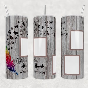 May include: A white tumbler with a wood grain design and a rainbow feather. The tumbler has two photo spaces and the text "Your Paws Were Ready But Our Hearts Were Not".
