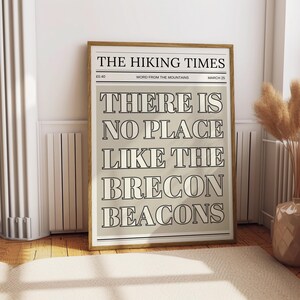 May include: A vintage-style newspaper print with the text "THE HIKING TIMES" and the quote "THERE IS NO PLACE LIKE THE BRECON BEACONS".