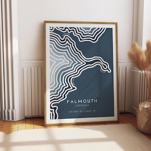 May include: A blue and white topographic map print of Falmouth, Cornwall. The print features a stylized map of the coastline with contour lines and the text "Falmouth, Cornwall 50.1526° N; 5.0663° W".