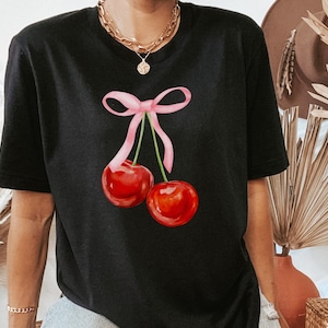 May include: Black t-shirt with a pink ribbon and two red cherries printed on the front.