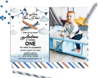 May include: A blue and white airplane birthday invitation with a watercolor background. The invitation features a photo of a baby boy sitting on a toy airplane. The text on the invitation reads "Oh Haw Time Flies!" and "Our Little Pilot Andrew is Turning One. Fly Over to Celebrate! Saturday August 29th 3:00PM Andrew's Airport 2458 Flying High Blvd Up in the Air, TX 24589 RSVP Angie at 548-254-3695 by 8/15"
