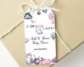 May include: A white Halloween-themed baby shower gift tag with watercolour illustrations. The tag features a ghost holding a flag that says "Boo!" and the text "A Little Boo! is almost due!" with the names "Anita & Thomas".
