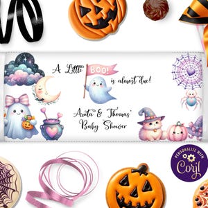 May include: A baby shower candy bar wrapper with a Halloween theme. The wrapper features illustrations of ghosts, pumpkins, a cat in a witch hat, and the text "A Little Boo! is almost due!" in a whimsical font. The names "Anita & Thomas" are also included.