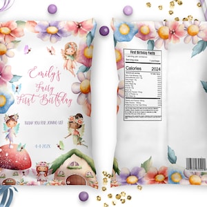 May include: A white favor bag with a pink and purple floral design. The bag features a fairy with wings and a wand, and the text "Emily's Fairy First Birthday".