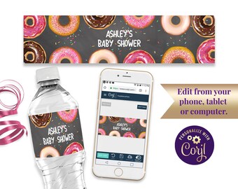 May include: A printable water bottle label with a donut theme. The label features a chalkboard background with colorful donuts and sprinkles. The text on the label reads "Ashley's Baby Shower".