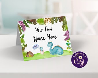 May include: A printable food tent card with a green, blue, and purple dinosaur design. The text on the card says "Your Food Name Here".