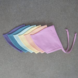 May include: A trio of ceramic mugs with a speckled, matte finish in cream, light grey, and dark grey. Each mug features a minimalist design and a rounded handle.