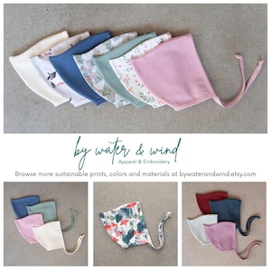 May include: A collection of baby bonnets in various colors and patterns, including solid pink, blue, and floral prints. The bonnets are arranged in a row, showcasing the variety of designs. The text "by water & wind" is also visible.